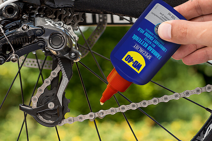 Fahrradkette wird mit Kettenöl geschmiert