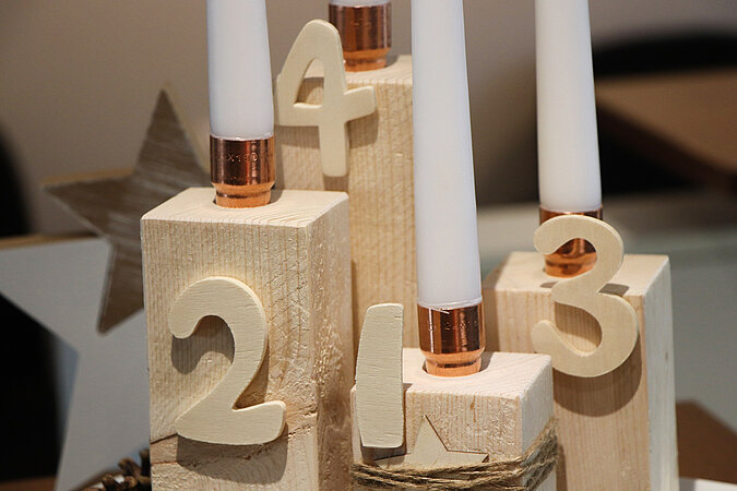 Nahaufnahme von einem Adventskranz aus kantholz mit angeklebten Zahlen aus Holz
