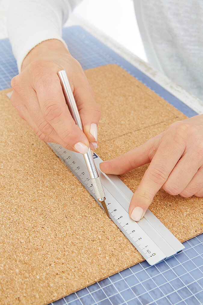 Für eine Pinnwand aus Kork im Fuchsdesign werden die Formen auf der Korkplatte ausgeschnitten