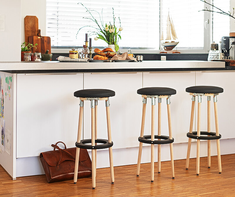 Barhocker selber bauen – moderne Holzbarhocker mit runder Sitzfläche an einer hellen Kücheninsel, DIY-Möbelidee für Küche oder Wohnbereich