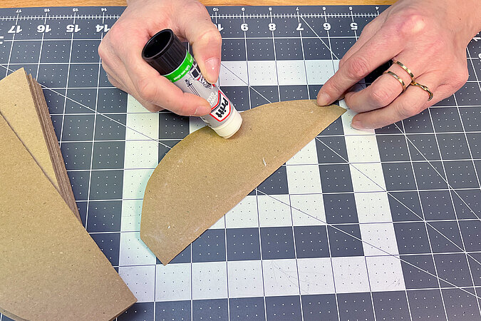 Bastelpapier wird mit einem Klebesstift bestrichen