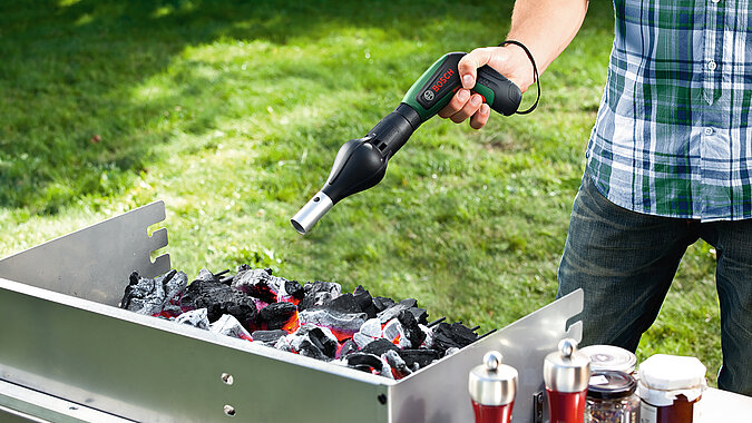 Festival Gadgets Akkus-Schrauber mit Gebläseaufsatz im Einsatz zum schnellen Entfachen von Holzkohle beim Camping und Festival