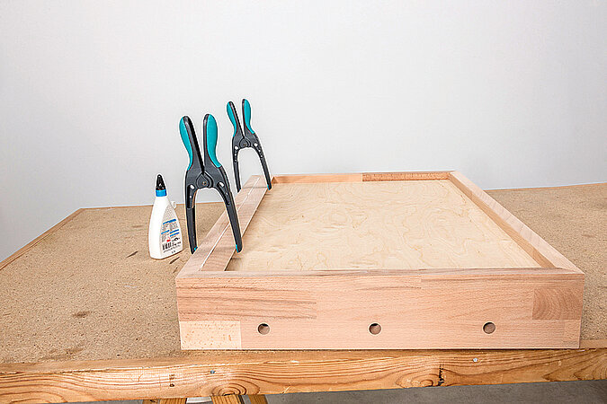 Wandgarderobe aus Kickerfiguren bauen mit verleimter Holzkonstruktion und Zwingen beim Trocknen des Rahmens auf der Werkbank