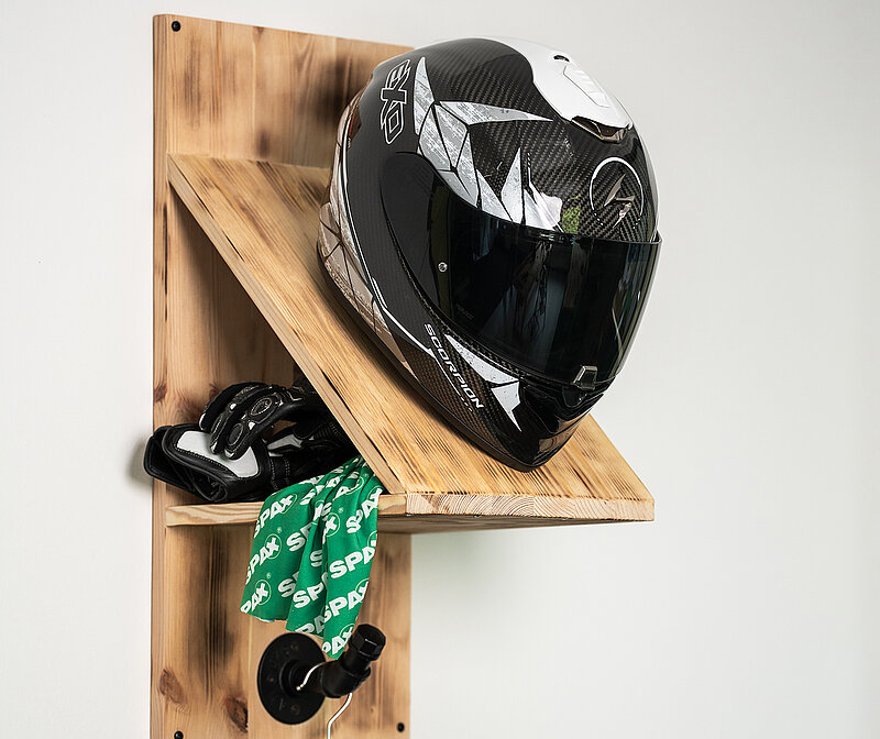 Selbstgebaute Helm-Garderobe aus angeflämmten Leimholz, bestückt mit Helm, Motorradhandschuhen, SPAX-Halstuch und Mottorradjacke