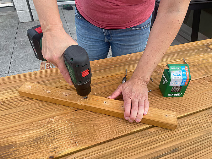 Grillplatz für die Terrasse bauen: Versenken der Schraublöcher mit Akkuschrauber – saubere Vorbereitung der Ablagebretter für bündige Verschraubung bei der DIY-Grillstation im Außenbereich.
