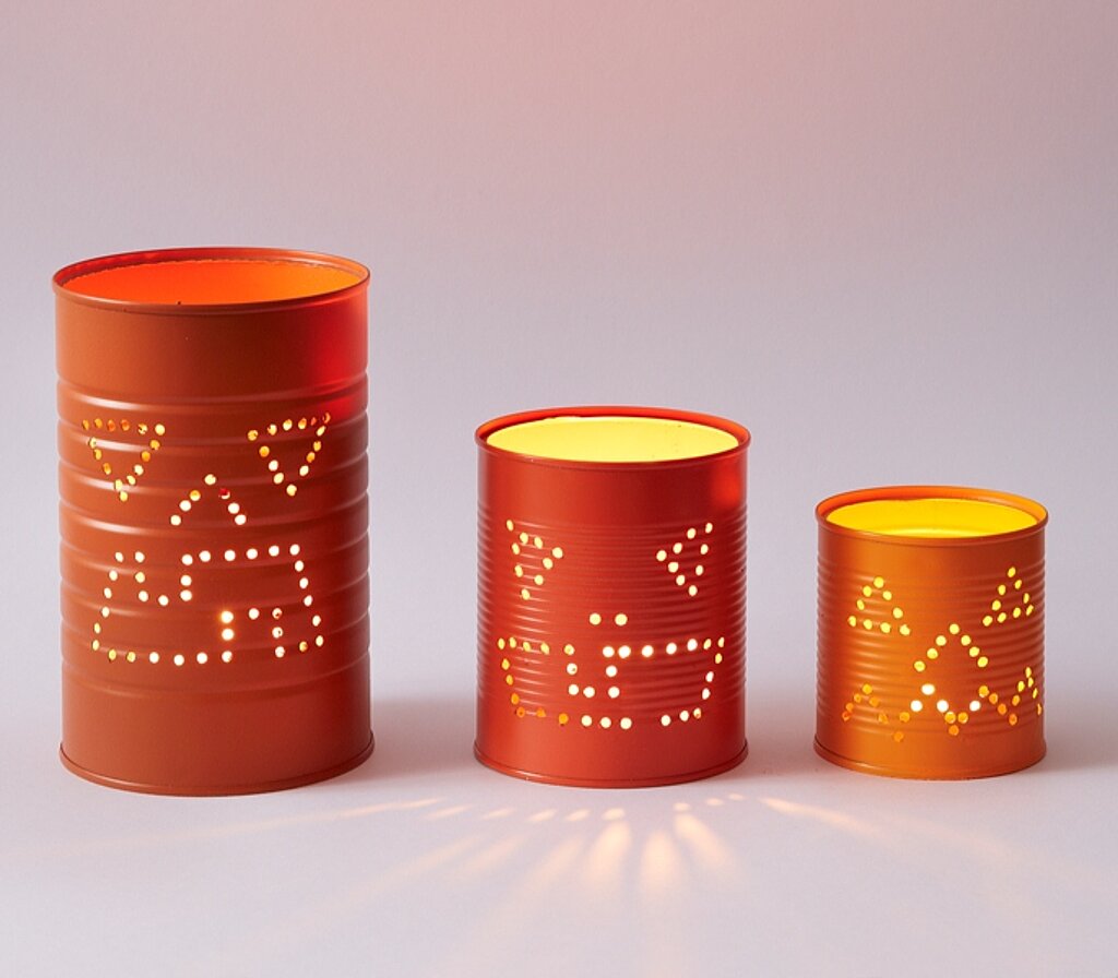 Halloween-Laternen selber bauen – drei unterschiedlich große Laternen aus orangefarbenem Papier mit ausgeschnittenen Gesichtern, perfekt als kreative DIY-Dekoidee für Halloween.