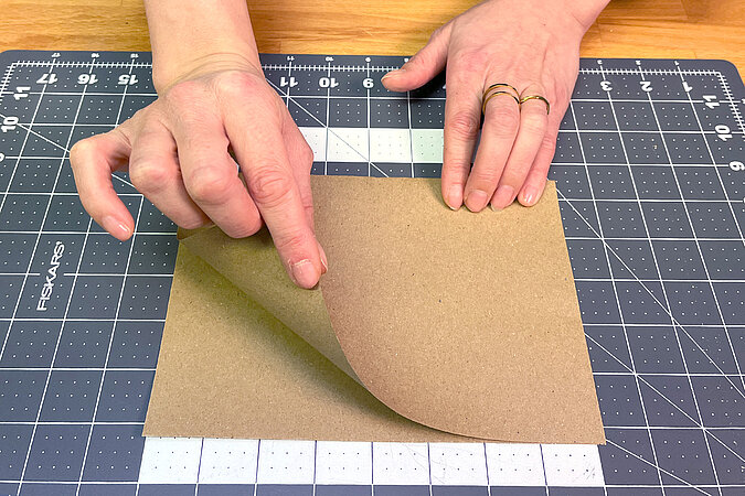 Ein Blatt Bastelpapier wird gefaltet