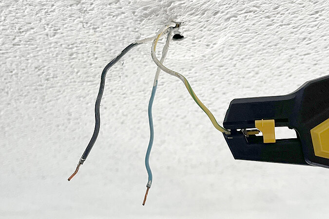 Das gelb-grüne Kabel wird mit einer Abisolierzange vorbereitet