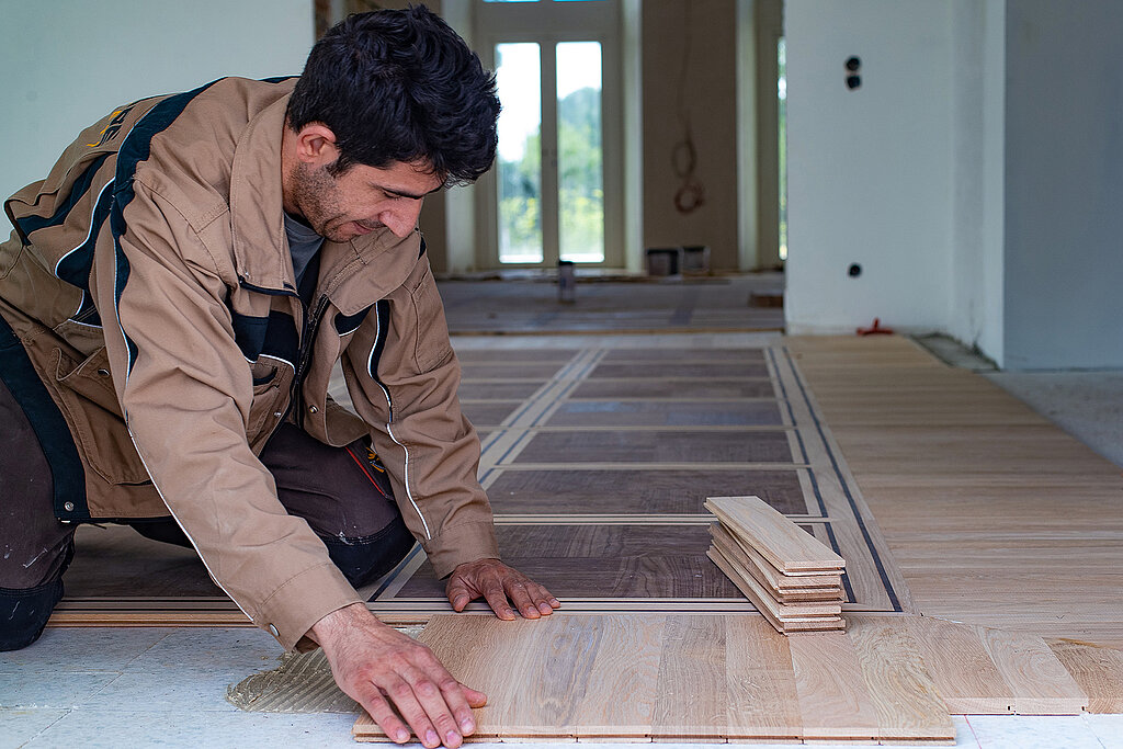 Handwerker verlegt Parkett