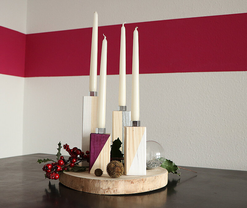 Adventskranz aus Kanthölzern steht schön dekoriert auf dem Esstisch