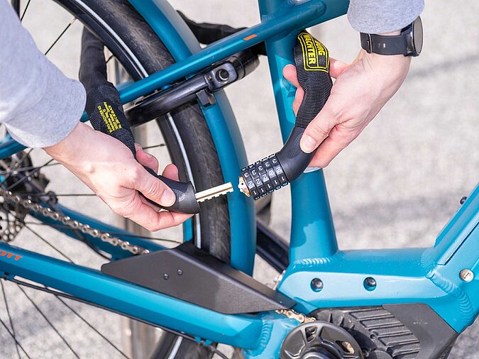 Mann-schliesst-Fahrrad-mit-Zahlencode-Schloss-ab