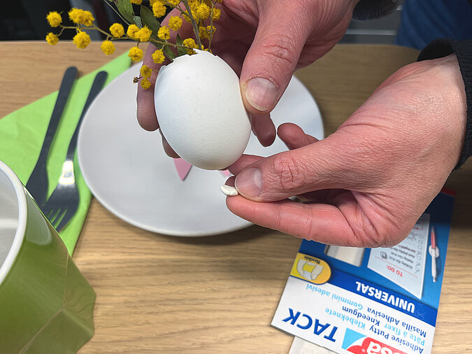Osterkranz aus Eierschalen basteln mit bemalen eines Eis in kräftigem Rot als dekoratives Highlight für den DIY-Osterkranz