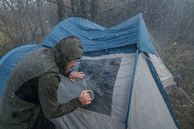 Festival Gadgets Riss im Zelt wird im Regen mit Reparaturband repariert für besseren Wetterschutz beim Camping