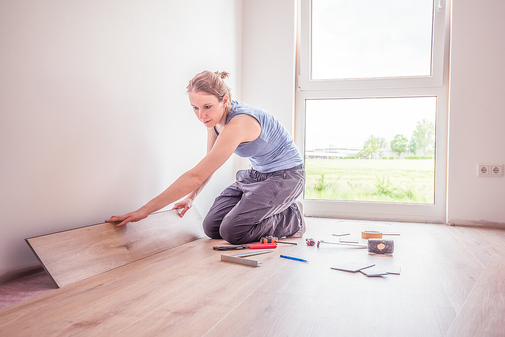 Frau verlegt Laminatboden