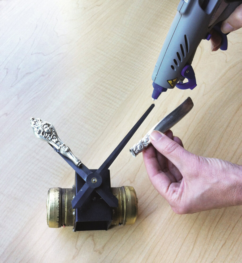 Wanduhr aus Beschlägen: Besteck an Uhrzeiger kleben