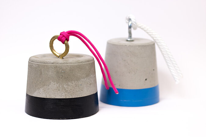 Türstopper aus Beton selber machen – fertige Beton-Türstopper mit farbigem Sockel und Kordelgriff, modernes DIY-Wohnaccessoire für Türen