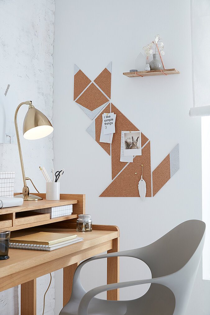 Eine selbstgebastelte Pinnwand aus Kork im Fuchsdesign hängt neben einem Schreibtisch an der Wand