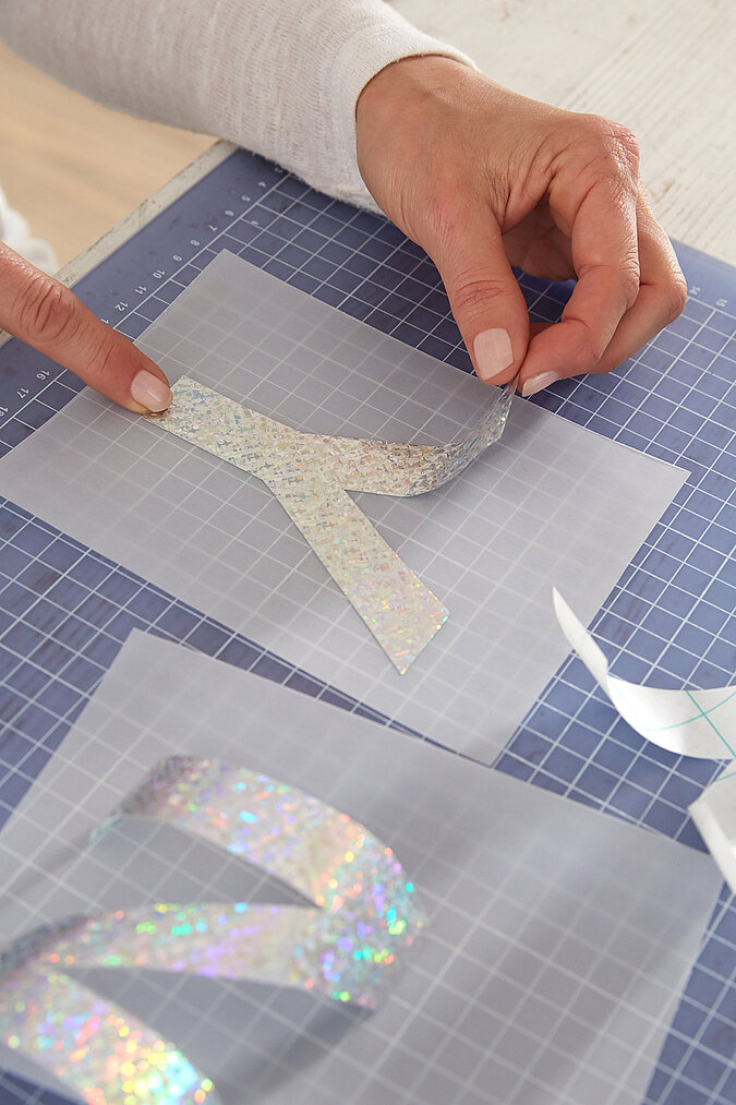 Ausgeschnittene Buchstaben werden auf Transparentpapier geklebt