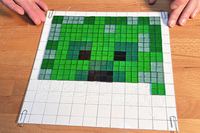 Creeper-Deko-Leuchte basteln mit vollständig gelegtem Mosaikbild des Creeper-Gesichts auf der vorbereiteten Rastervorlage