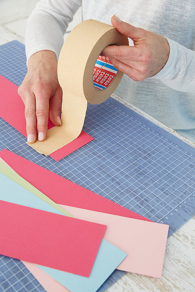 Einschulung Wimpelkette basteln mit doppelseitigem Klebeband und buntem Papier für individuelle Deko zur Einschulung