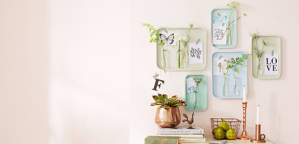 Wanddeko mit Pflanzen aus dekorativen Wandvasen, kreative DIY-Wandgestaltung mit kleinen Grünpflanzen und Gläsern als stilvolle Wohnraumdekoration