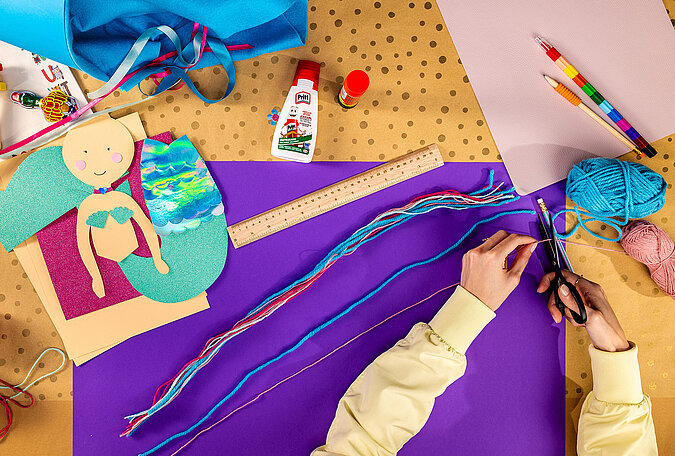 Schultüte Meerjungfrau basteln mit vorbereiteten Wollsträhnen in Blau, Rosa und Türkis für die Frisur