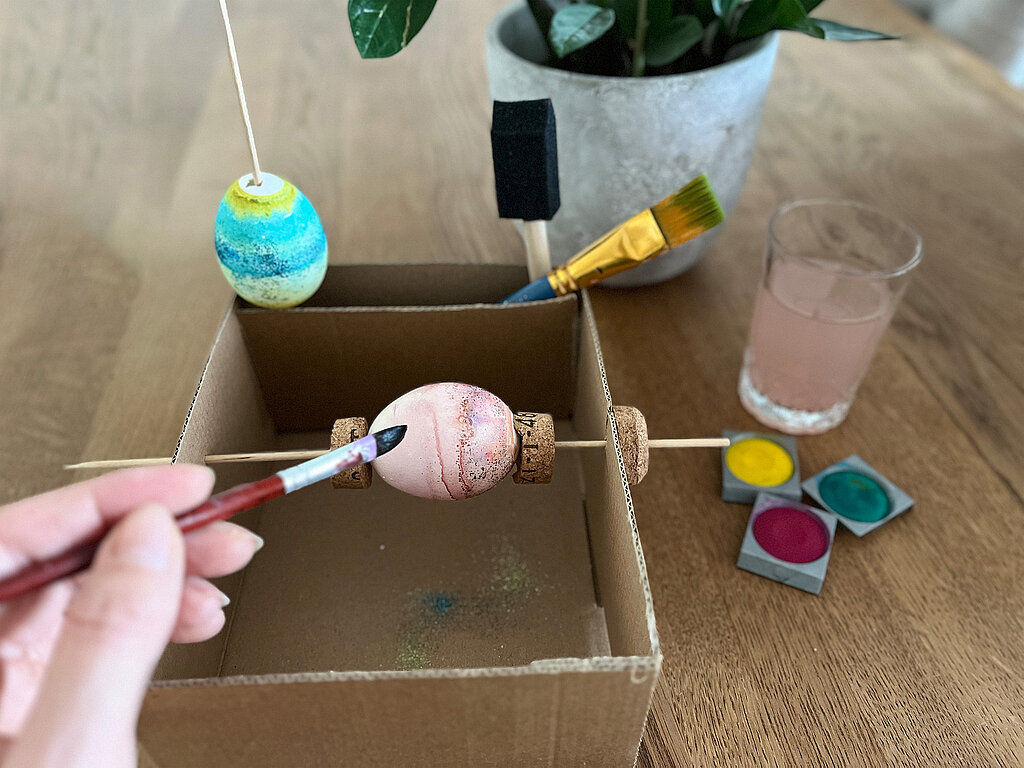Selbst gebastelte Malmaschine zum Ostereier bemalen aus Karton