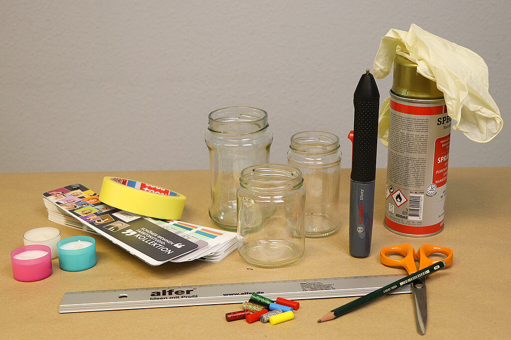 Einschulung Wimpel-Windlicht DIY-Materialien mit Gläsern, Papier, Schere und Sprayfarbe für kreative Einschulungsdeko vorbereiten