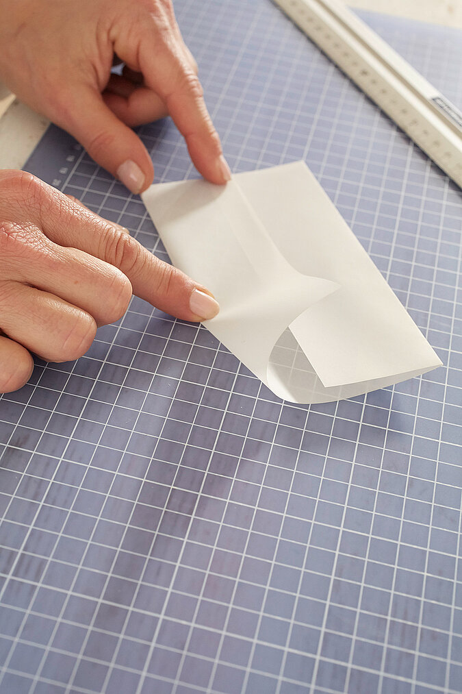Transpartentpapier wird zur Mitte hin gefaltet