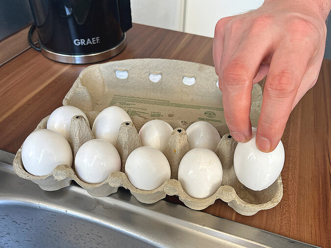 Osterkranz aus Eierschalen basteln mit getrockneten Eierschalen auf einem Tablett als stabile Grundlage für die Osterdeko