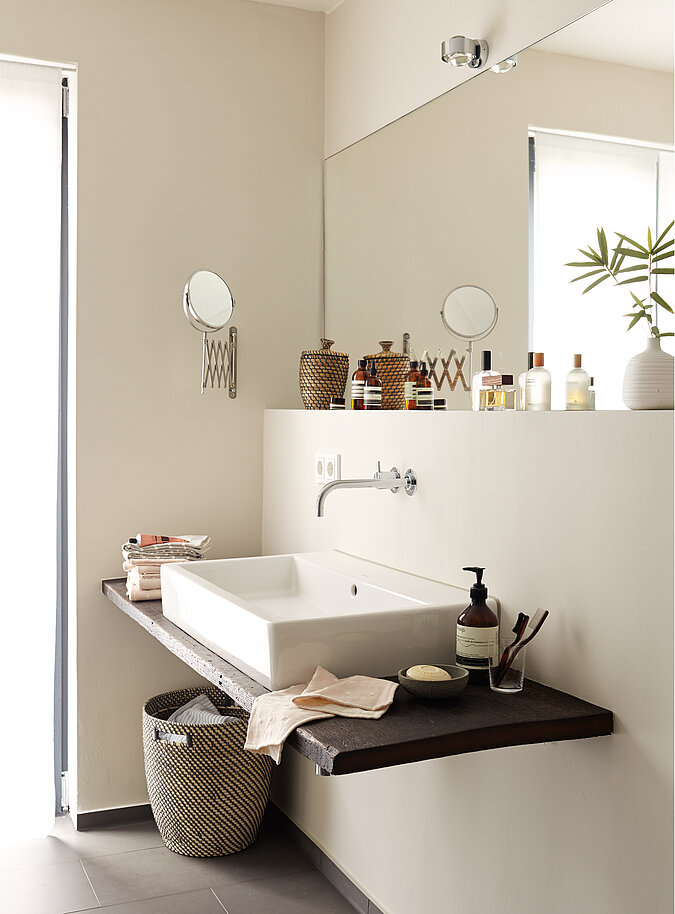 modernes Badezimmer mit warmer beiger Wandfarbe und dunkleren edlen Accessoires