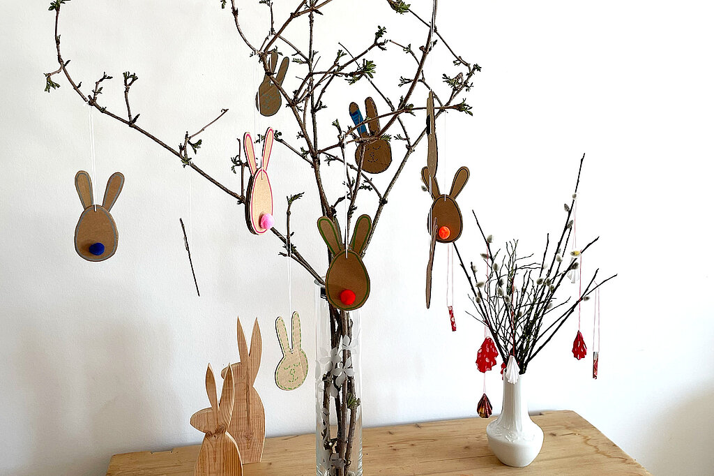 Dekorierter Osterstrauch mit Osterhasen aus Karton