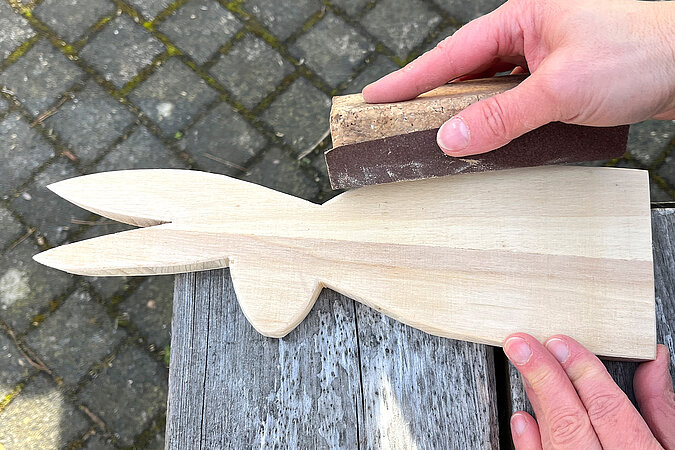 Kanten der Hasenfigur wird mit Schleifklotz und Schleifpapier glatt geschliffen