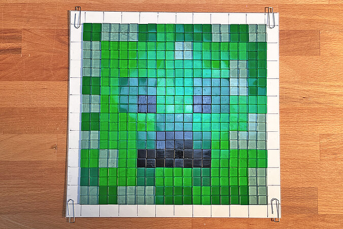 Creeper-Deko-Leuchte basteln mit fertig geklebtem Mosaikbild und eingeschaltetem Licht zur Kontrolle der Leuchtwirkung