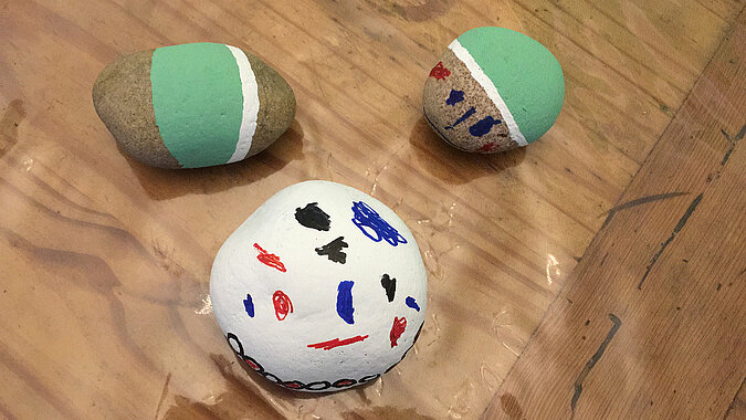 Tipps zum Heimwerken mit Kindern: Bunt bemalte Steine mit Mustern und Gesichtern als kreative Bastelidee – einfaches DIY-Projekt für Kinder mit Farbe und Fantasie.