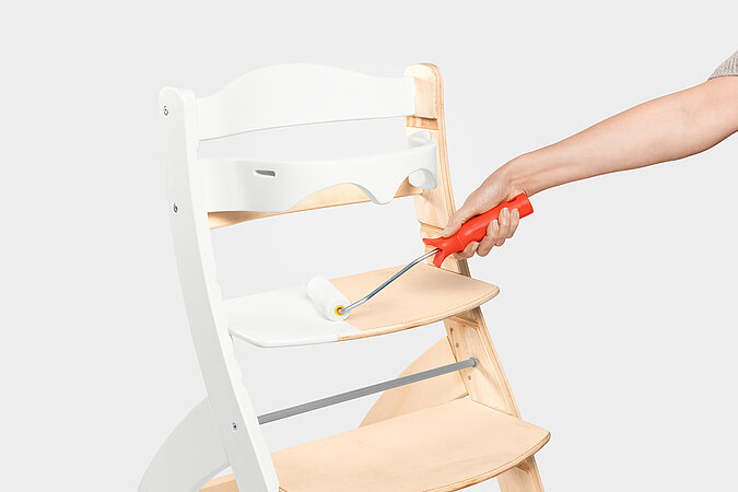 Kindermöbel streichen - Hochstuhl, die ersten Holzelemente mit einer Lackrolle weiß streichen für ein frisches Design