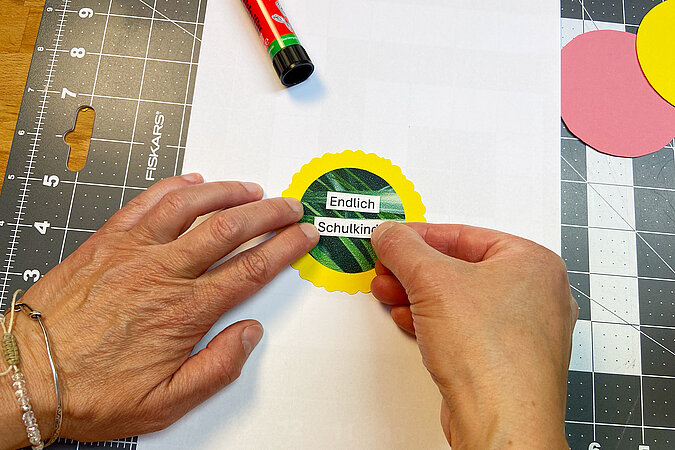 Einschulung Orden basteln mit Schriftzug „Endlich Schulkind“ auf der bunten DIY Plakette