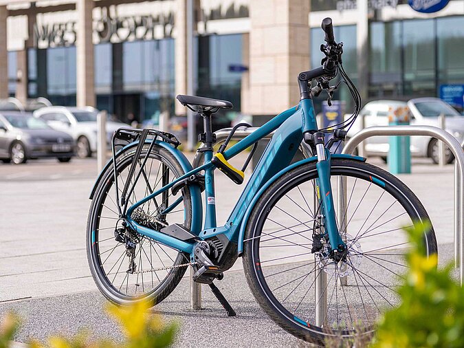 E-Bike-mit-Buegelschlosss-an-Pfahl-gekettet