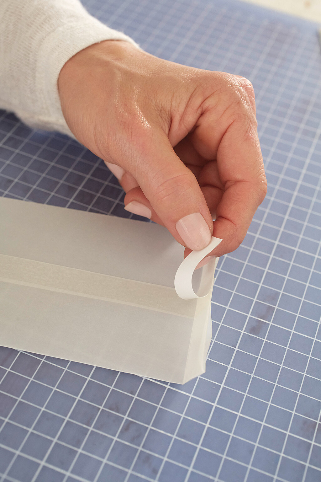 Dr umgefaltete Boden des Tütchens wird mit Klebeband fixiert