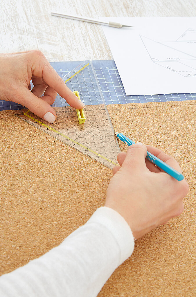 Für eine Pinnwand aus Kork im Fuchsdesign werden die Formen auf der Korkplatte angezeichnet