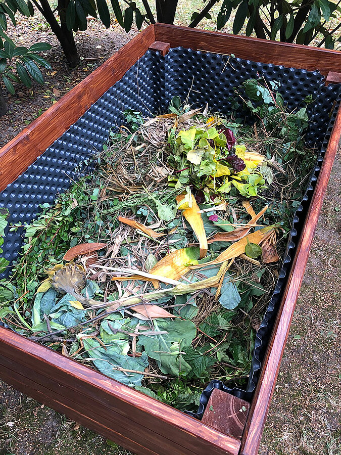 Hochbeet im Trend: Mischung aus Gartenabfällen und organischem Material als Kompostschicht im Hochbeet