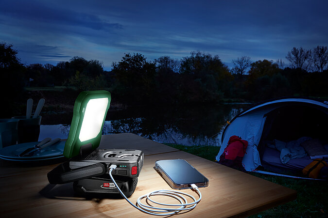 Festival Gadgets mobile LED-Lampe mit Powerbank auf Tisch vor Zelt für Licht und Energieversorgung beim Festival