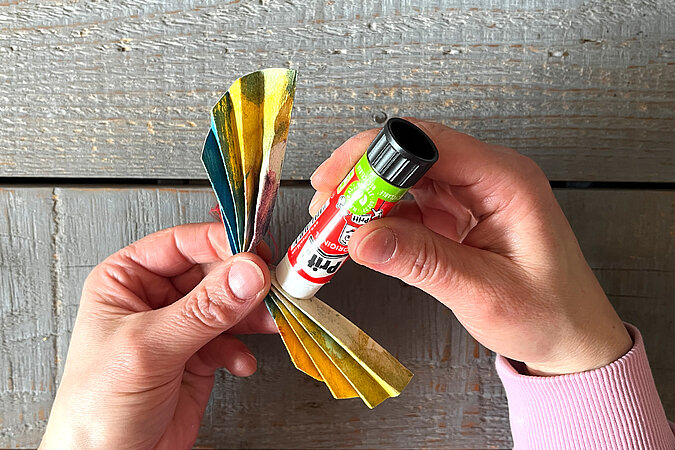 gefaltetes Papier wird mittig zusammengeklebt