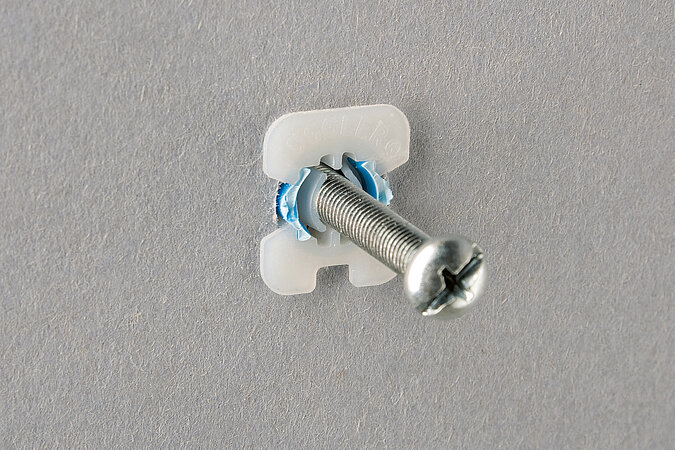 Schraube steckt im speziellen Hohlraumdübel in der Gipskartonwand