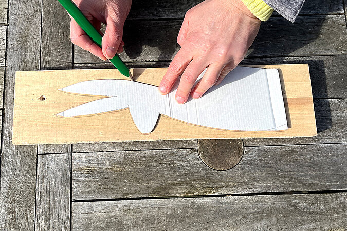 Hasenform wird mit Schablone & Bleistift auf ein Brett übertragen