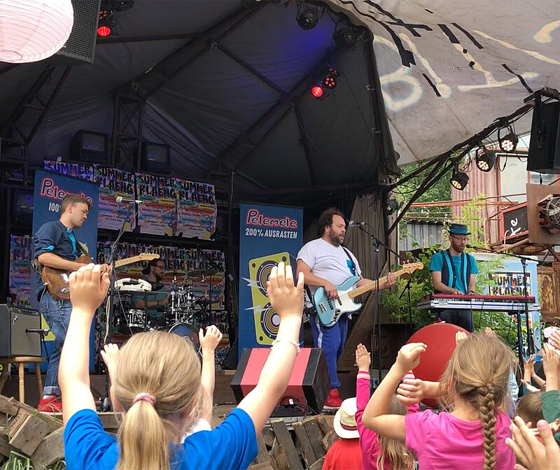 Festival-Gadgets – Konzertbühne mit feiernden und tanzenden Kindern