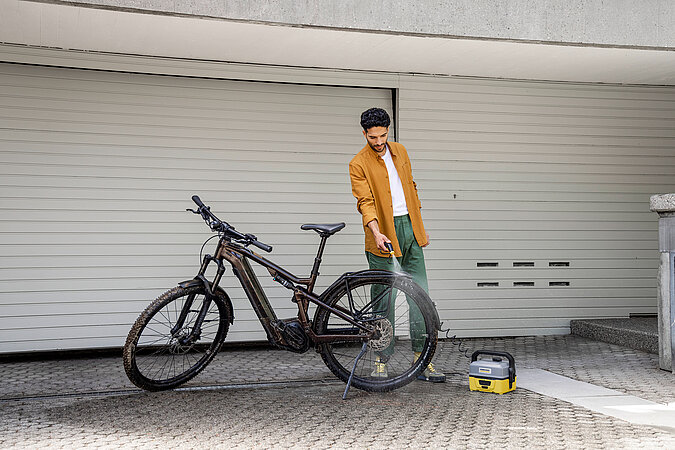 Verschmutzes Fahrrad wird mit Druckreiniger gesäubert