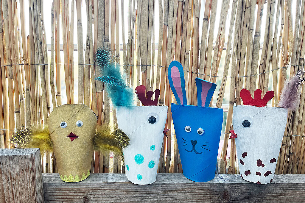 aus leeren Toilettenrollen gebastelte Osterdeko in Form von bunten Tierchen wie Hase, Henne, Huhn und Kueken