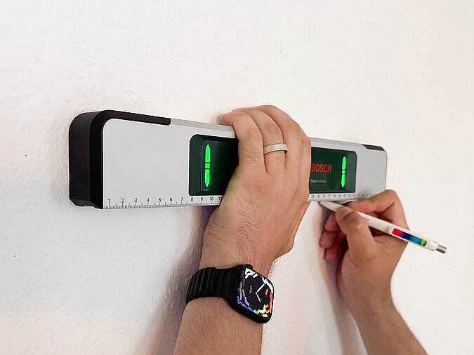 Bild mit Hilfe einer LED-Wasserwaage an Wand ausrichten
