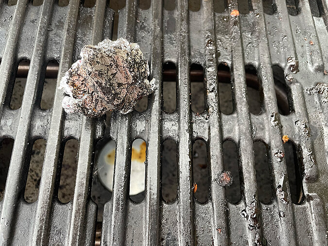 Festival Gadgets DIY-Grillreinigung mit zusammengeknüllter Alufolie auf dem Rost für schnelles Säubern beim Camping